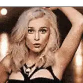 a woman with blonde hair and blue eyes is wearing a black bra and tie