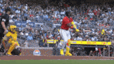 a baseball player is swinging a bat at a pitch in front of a gulf sign