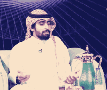 a man with a beard wearing a head scarf and a microphone