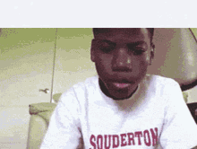 a young man wearing a souderton t-shirt
