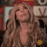 a woman in a leopard print shirt is looking up at the camera .