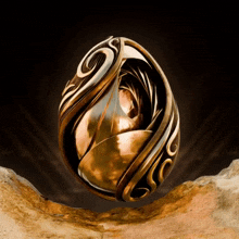 a gold ring with a swirl on it is on a rock