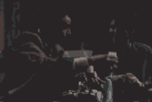 two men are toasting with champagne while sitting on a couch in a dark room .