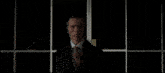 a man in a black suit is walking down a city street at night