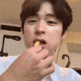 a close up of a person eating a piece of food with the number 2 on the wall behind them