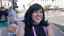 a woman wearing a purple lanyard that says ' la always ' on it