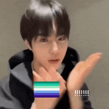 a close up of a person 's face with a rainbow flag in the corner
