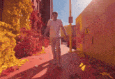 a man in a white shirt is walking down a street with a sign on the wall that says ' italy ' on it