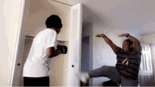 a man wearing boxing gloves kicks another man in the leg