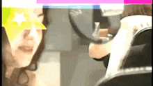a woman is looking at herself in a mirror with a yellow star on her eye
