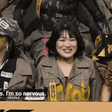 a woman is smiling in front of a sign that says ' i 'm so nervous ' on it