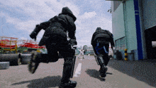 a man in a hooded jacket is running towards a building