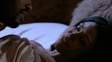 a man and a woman are laying on a bed and the man is looking at the woman