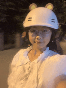 a woman wearing glasses and a white helmet with ears