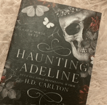 a book called haunting adeline by h.d. carlton with a skull on the cover