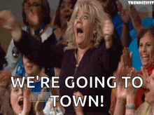 a woman in a crowd is screaming with the words we 're going to town behind her