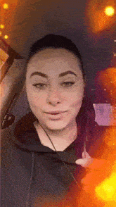a woman wearing headphones is sitting in a car and looking at the camera