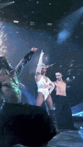 a group of people are dancing on a stage and one of them is giving the middle finger