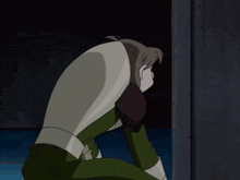 a woman in a green top stands next to a man in a black suit with an x on it