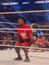 a man is kneeling in a wrestling ring during a match .