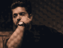 a man with a watch on his wrist looks at the time