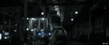 a person is standing in a dark room with a blue light coming out of their hand .