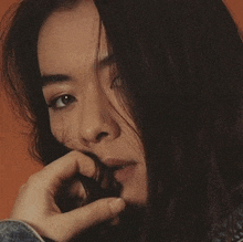 a close up of a woman with her hand on her face