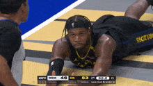 a basketball player laying on the floor with a scoreboard behind him that says espn mem 46 gs 52.2 bonus 21