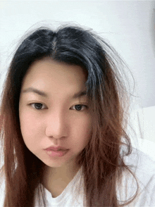 a woman 's face is shown with a white shirt on