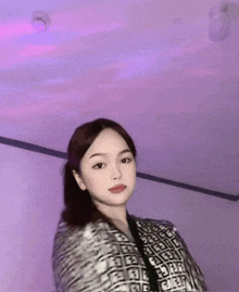 a woman in a zebra print jacket is standing in a room with a purple ceiling .