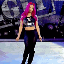 a woman with pink hair is dancing on a stage .