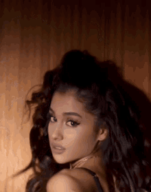 a close up of a woman 's face with her hair in a ponytail .