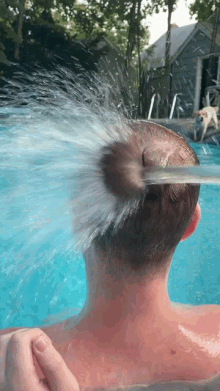 a man 's head is being sprayed with water from a hose