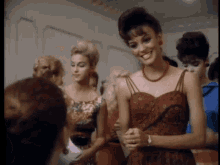 a woman in a red dress is smiling in front of a crowd
