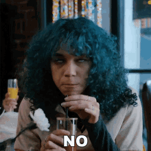 a woman with blue hair is drinking from a glass and the word no is on her face