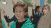a boy wearing a green hoodie with trt1 written on the bottom right corner