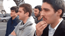 a group of young men are standing in a parking lot and one of them has a north face jacket on