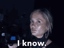 a woman holding a camera says i know in white letters