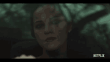a close up of a woman 's face in a car with a netflix logo on the bottom .