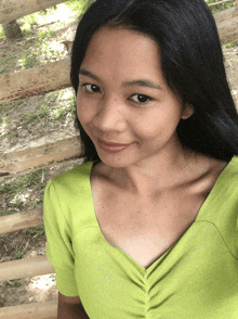 a woman wearing a green shirt is smiling for the camera