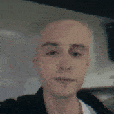a close up of a bald man 's face with a blurred background