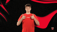 a young man wearing a red shirt that says tribe gives a thumbs up
