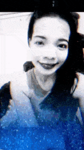 a black and white photo of a woman smiling with a blue background