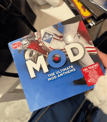 a person is holding a cd of mod anthems