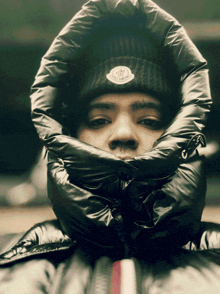 a man wearing a black beanie with the word moncler on the front