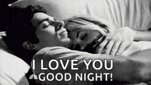 a man and a woman are sleeping in a bed and the man is hugging the woman .