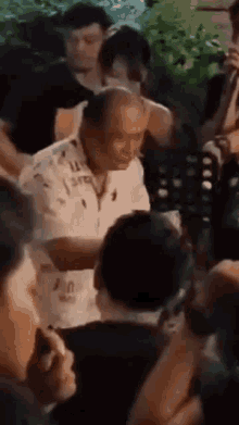 a man in a polo shirt is standing in a crowd .