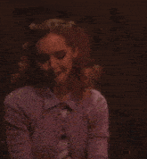 a woman in a purple cardigan is holding a glass of wine .