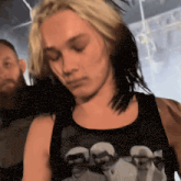 a woman with blonde hair is wearing a black tank top