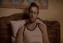a man in a tank top has a bandage on his forehead